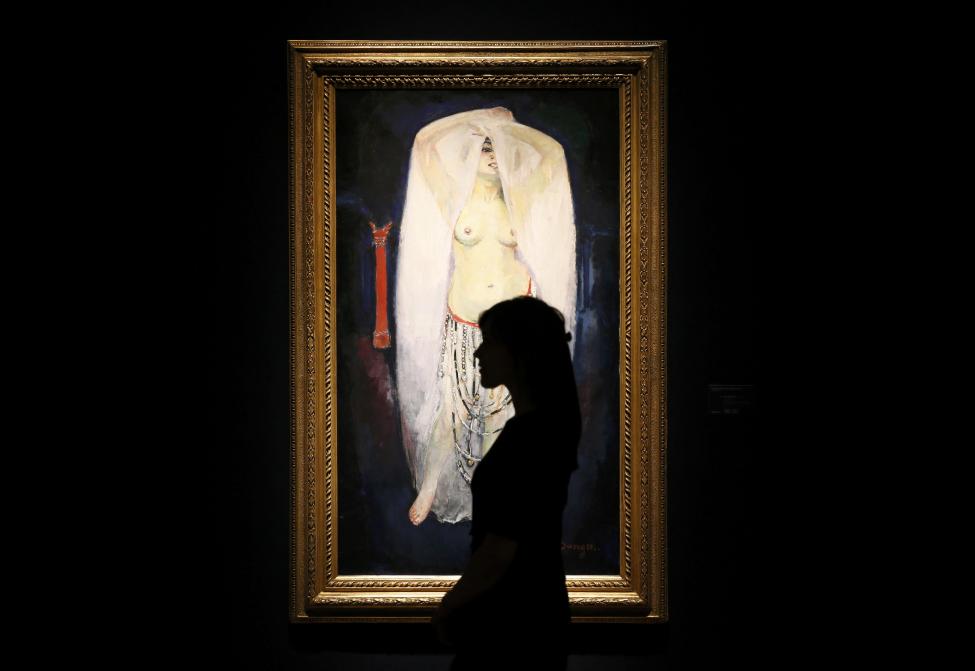 A member of staff is silhouetted as she poses in front of 'Anita en almee' by Kees Van Dongen at Christie's auction house in London