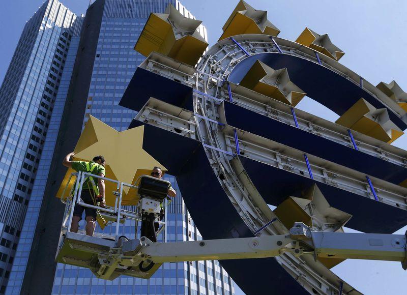 Workers dismantle Euro sign sculpture for maintenance in front of former headquarters of ECB in Frankfurt