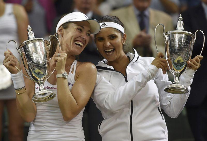 Martina Hingis of Switzerland and Sania Mirza of India pose with their trophies after winning their Women's Doubles Final match against Elena Vesnina and Ekaterina Makarova of Russia at the Wimbledon Tennis Championships in London