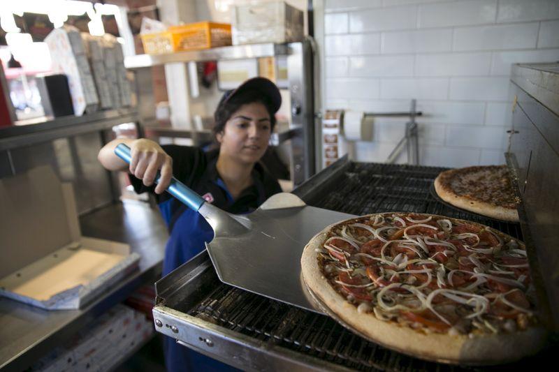 A worker takes a vegan pizza out of the oven at a Domino's Pizza restaurant in Tel Aviv