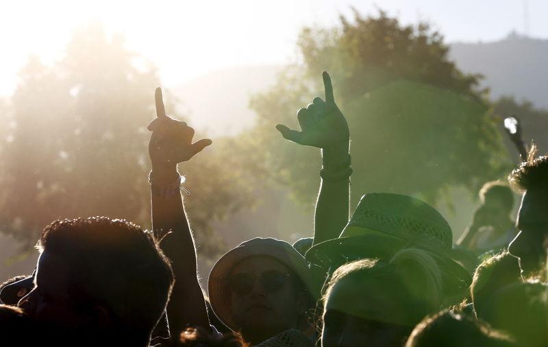 A reveler gestures during performance of Caravan Palace at Paleo Festival in Nyon